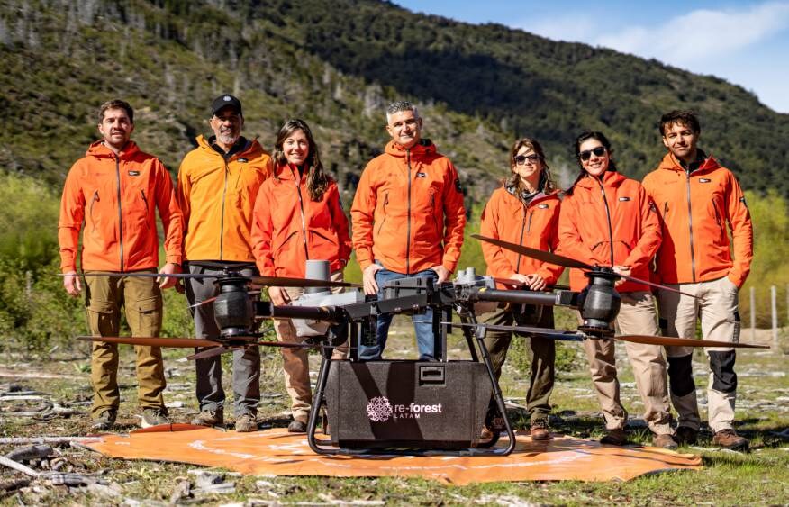 Equipo de re-forest LATAM en terreno junto a un dron de siembra