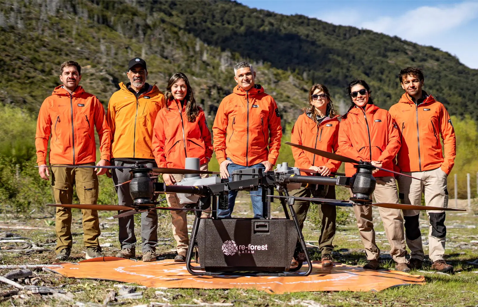 Equipo de re-forest LATAM en terreno junto a un dron de siembra